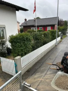 Gartenpflege mit geschnittenen Hecken und neuer Beetbepflanzung.